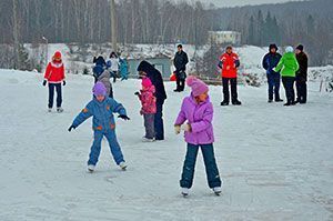 Дети катаются на коньках зимой